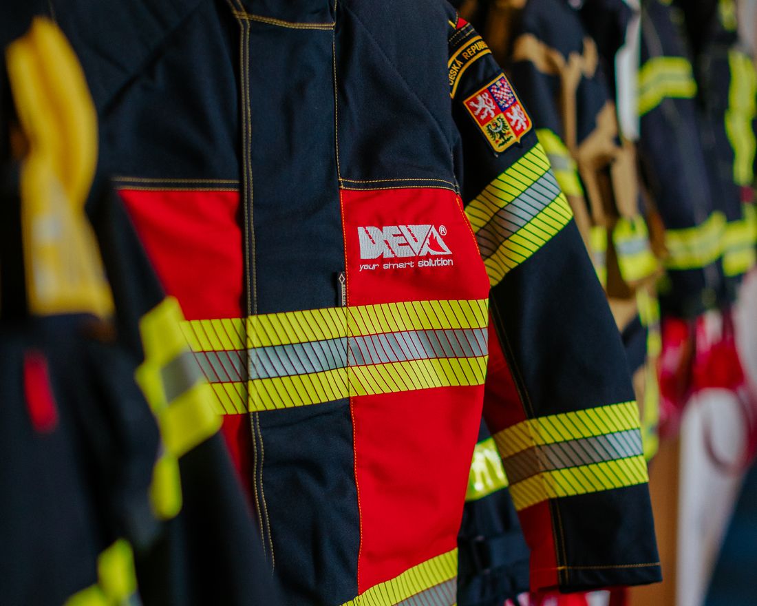 Saubere Feuerwehr-Einsatzjacke mit Reflexstreifen hängt einsatzbereit auf dem Bügel