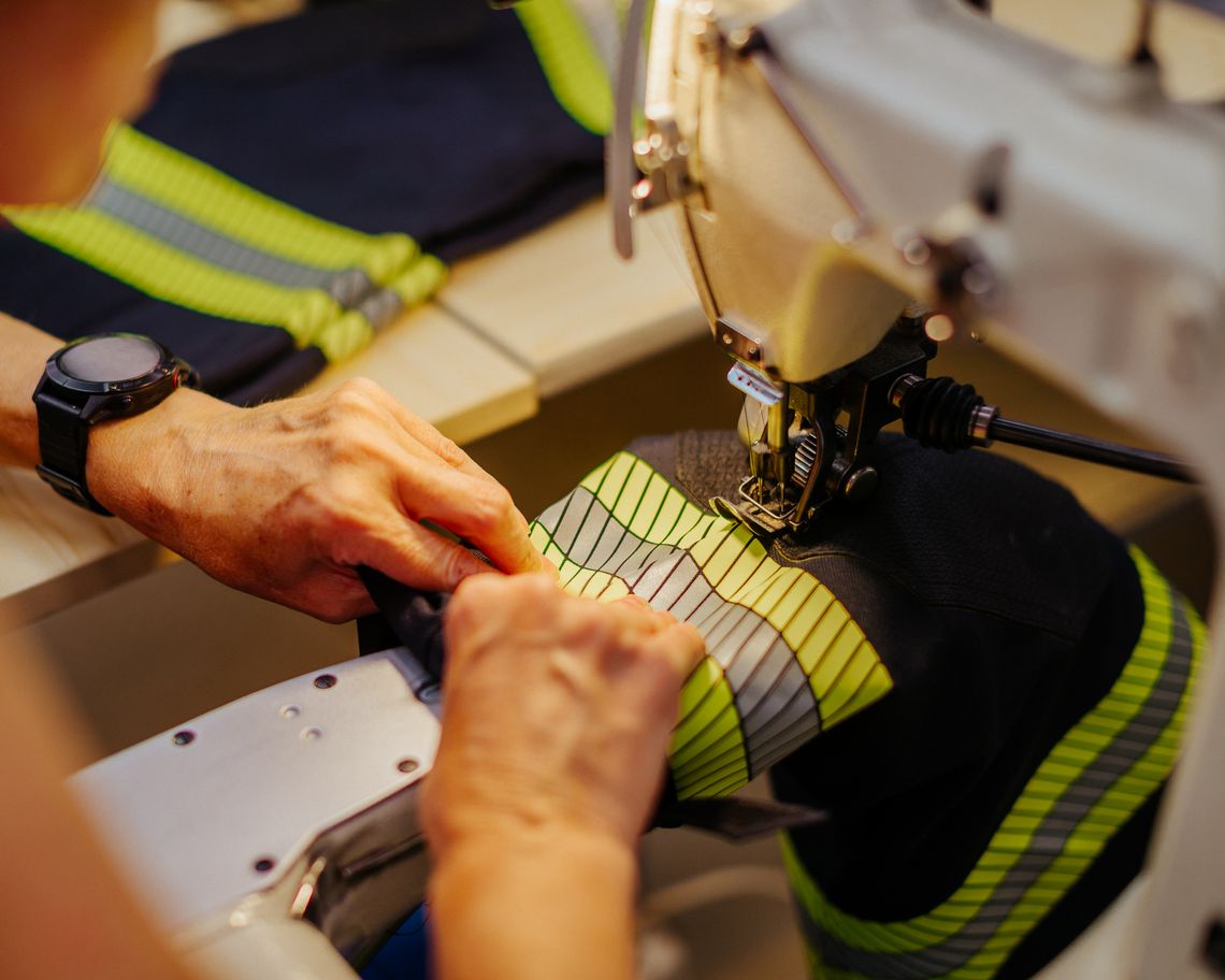 Reflexstreifen an Feuerwehrschutzkleidung wird an der Industrienähmaschine fachgerecht vernäht